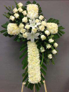 Cruz de claveles y rosas con copete en tonos blancos